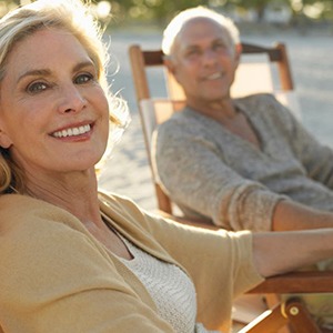 Smiling older couple relaxing on the beach