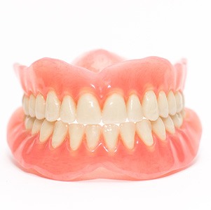 Full set of dentures pictured against white background