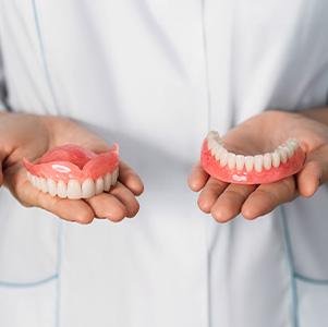 Dental professional holding dentures