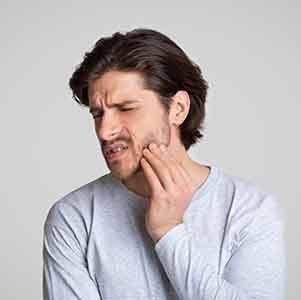 Man in grey shirt with tooth pain